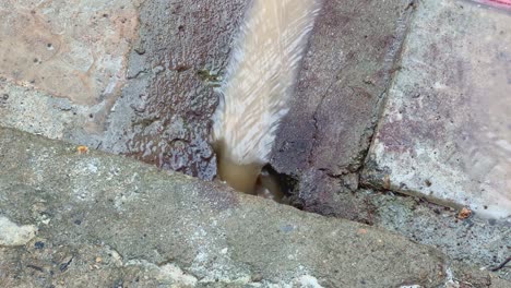a rainwater flowing through the gutter line made on concrete