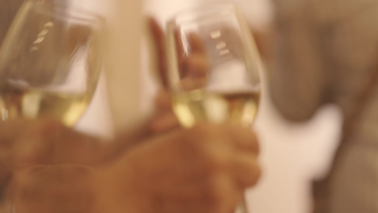 Una persona anziana che tiene in mano calici di champagne