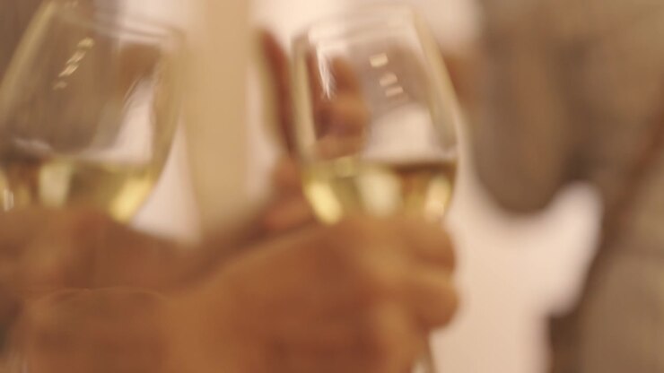 Una persona anziana che tiene in mano calici di champagne