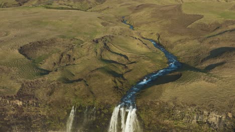 Toma-De-Drones-De-La-Famosa-Cascada-Islandesa-Seljalandsfoss-Y-Paisaje-Verde-En-Un-Día-Soleado