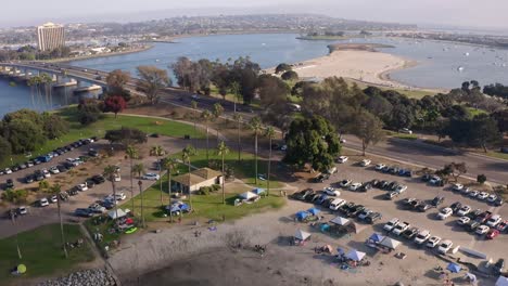 drone flyover of mission bay park in san diego with ocean and mountains in the background