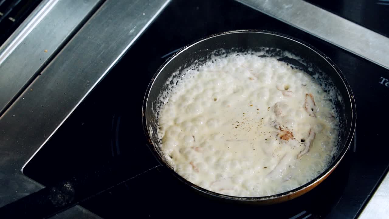 フライパンで美味しいソースを作る。料理人がフライパンで炒めた美味しい料理をかき混ぜています。シェフはレストランの熱いコンロで調理しています。料理のコンセプト