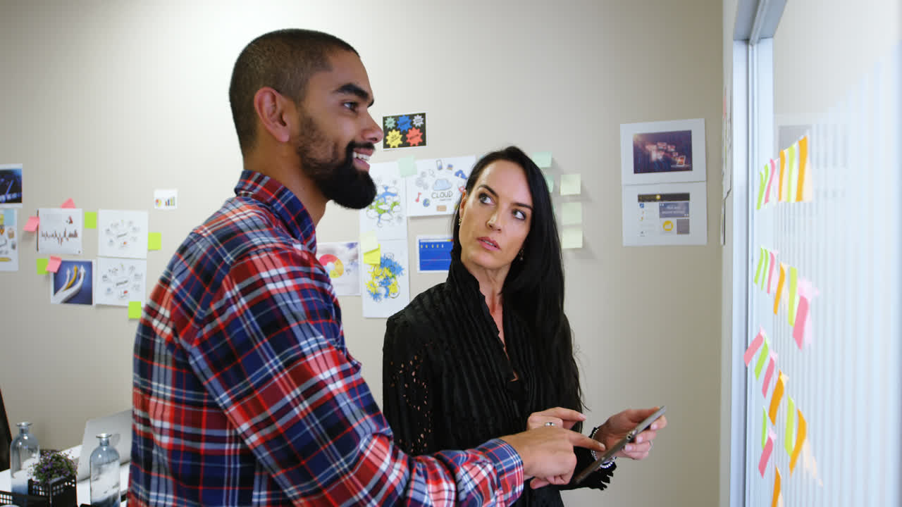 ejecutivos de negocios discutiendo sobre una tableta digital y nota adhesiva 4k
