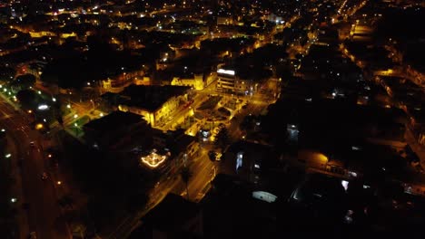 Night-time-lights-shine-through-a-city-as-drone-flies-backwards-and-upwards-revealing-the-entirety-of-the-city-with-lights-going-on-into-the-horizon