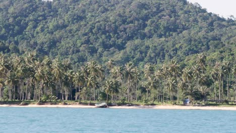 View-of-tropical-beach-and-mountain-from-the-sea,-sliding-shot