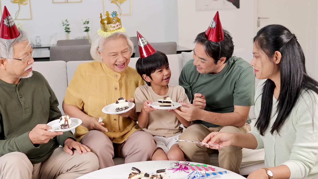 温かくお祝いムードの環境で、3世代がケーキ、笑い声、そして共有された瞬間と共に誕生日のお祝いを楽しんでいます。
