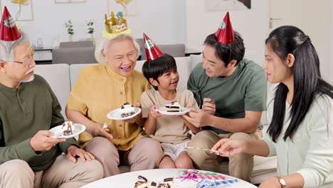 three generations enjoy a birthday celebration with cake, laughter, and shared moments in a warm, festive setting