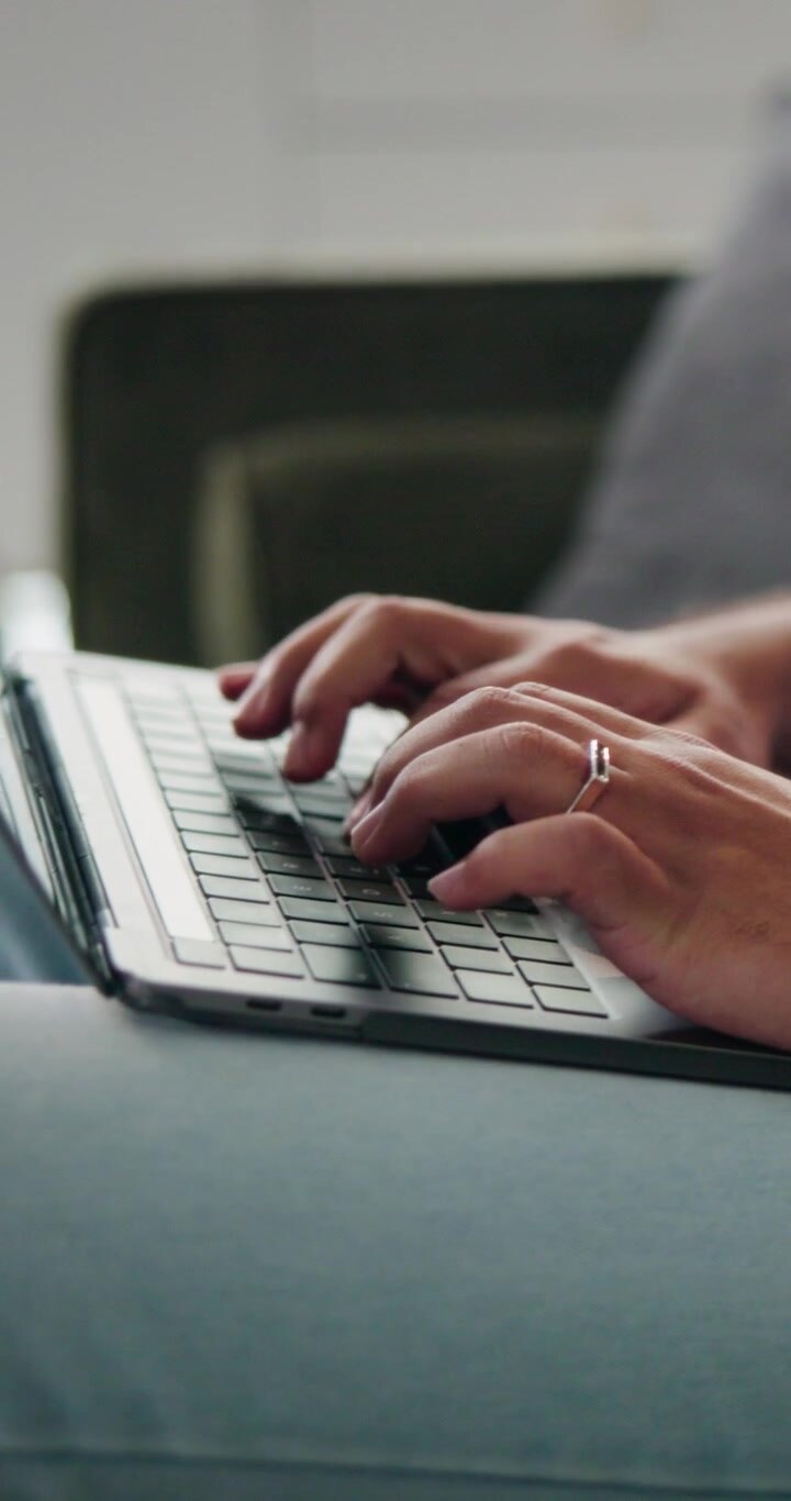 Person Typing on Laptop While Sitting at Home
