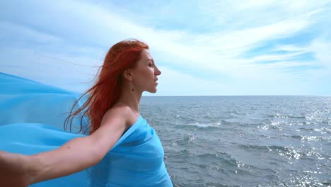 pregnant woman enjoying life. pregnant lady with blue cloth flying in wind