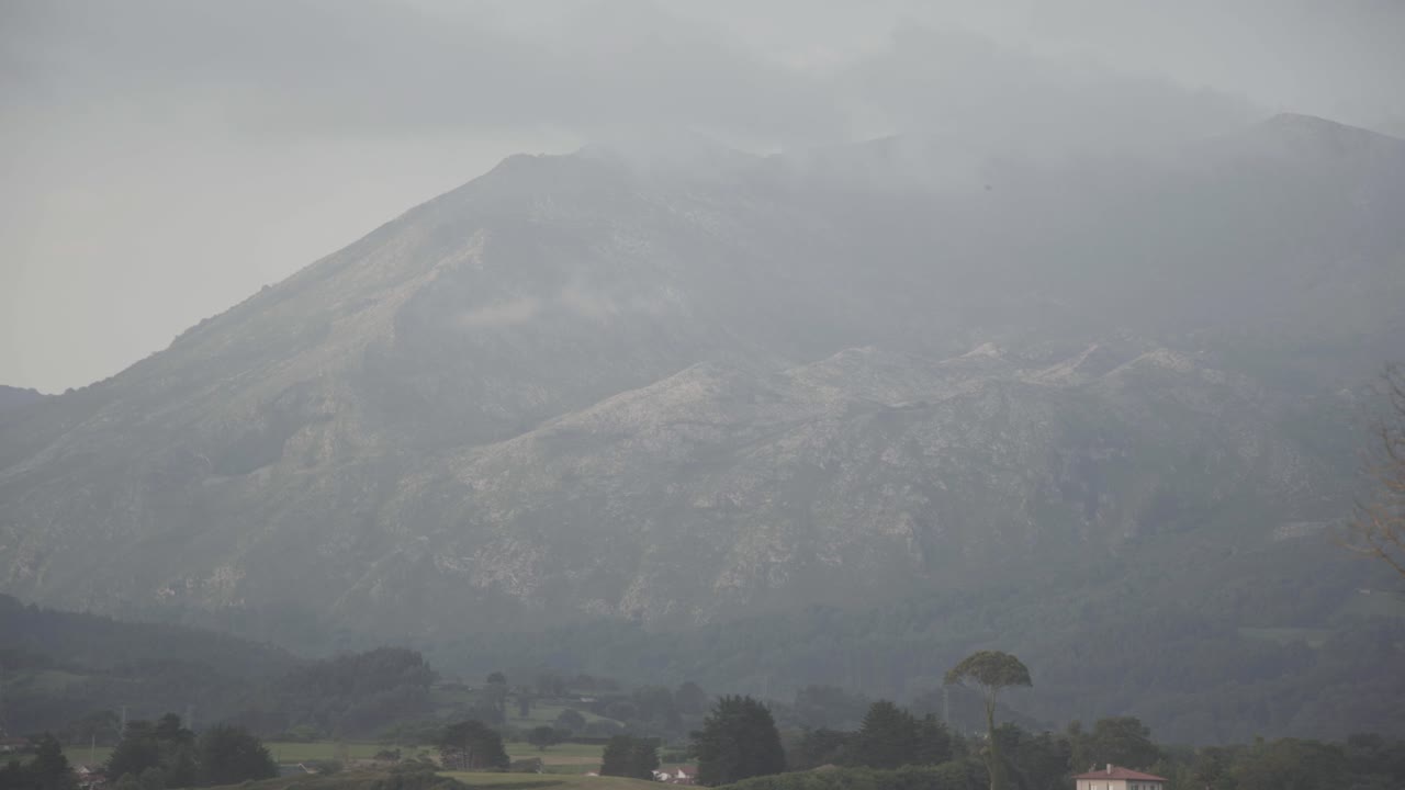 Groen landschap, mistige bergen op de achtergrond, Asturië, Spanje, statisch shot