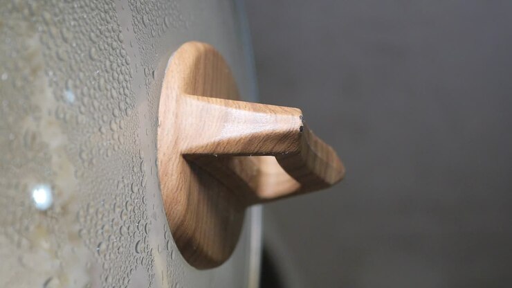 Primo piano di un manico di legno su un coperchio di pentola