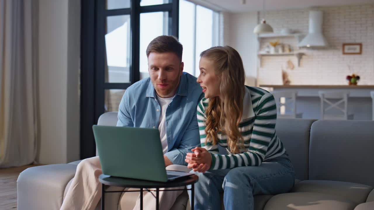 Husband wife talking video meeting looking laptop webcam at home sofa closeup
