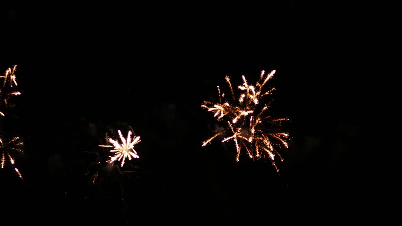 Spettacolo pirotecnico che esplode nel cielo notturno simultaneamente su un lungomare di una località turistica nel Sud-est asiatico per uno spettacolo internazionale di fuochi d'artificio