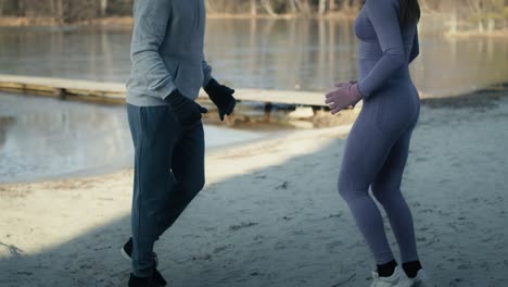 tilt up of adult caucasian couple warming up before winter swimming.