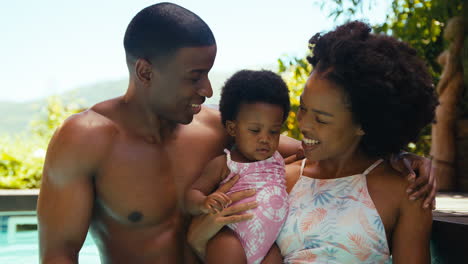 Family-With-Young-Daughter-Having-Fun-On-Holiday-In-Swimming-Pool-Together