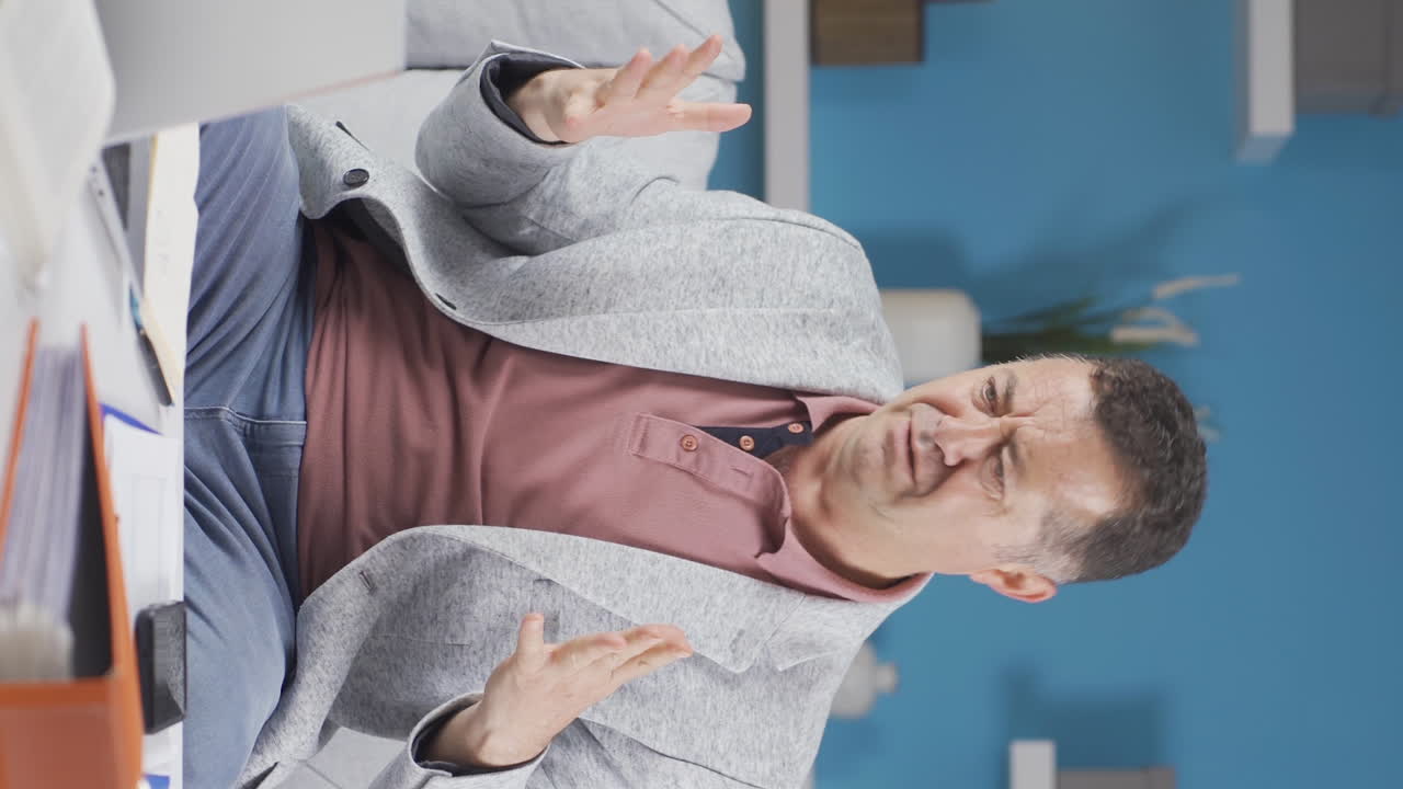 Vertical video of Home office worker old man's hands are shaking.