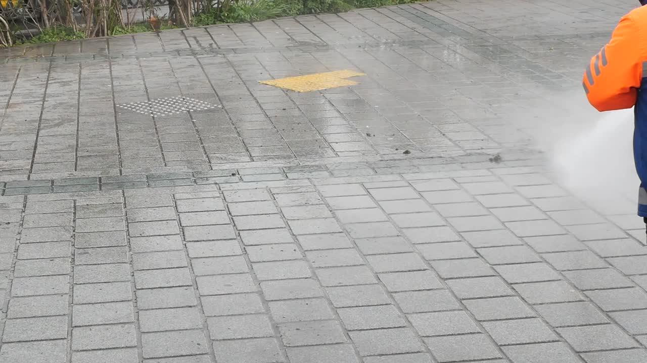 Worker Cleaning Sidewalk with High-Pressure Washer