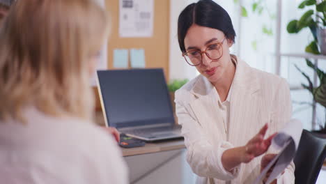 Women-Discuss-Sales-Report-During-Business-Meeting