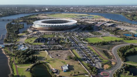 Aerial-approaching-shot-of-Optus-Stadium-with-Swan-River-during-sunset-time-in-Perth-City,-Western-Australia
