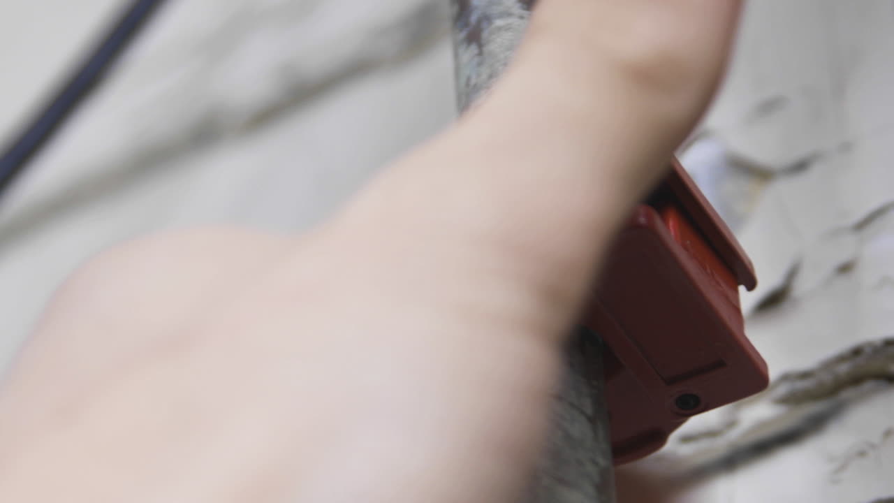 un vecchio tubo di rame viene tagliato da mani maschili utilizzando un tagliatubi