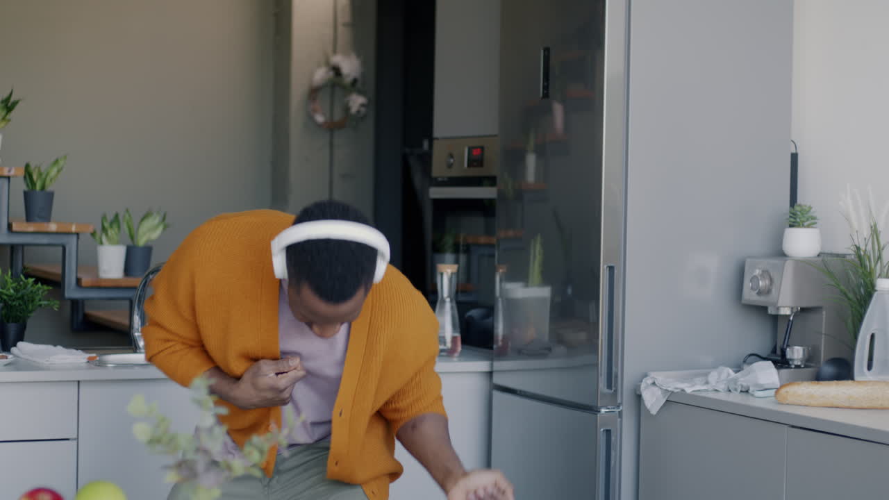 Man Dancing in Kitchen While Listening to Music