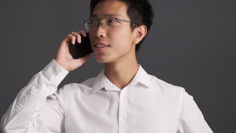 hombre asiático feliz llamando por teléfono inteligente.