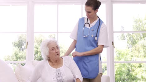 cheerful nurse talking with senior woman