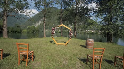 entorno de ceremonia de boda al aire libre junto a sillas de lago y arco hexagonal en plataforma rodante de césped