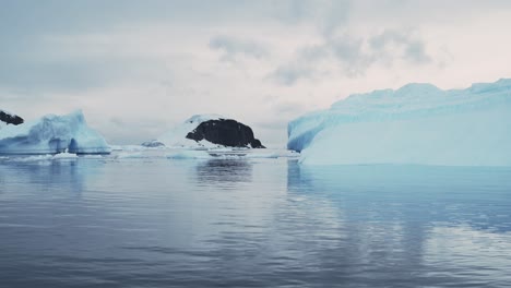 Paisaje-De-La-Costa-Antártica-Al-Atardecer,-Montañas-E-Icebergs-Con-Espectaculares-Nubes-Al-Atardecer-Y-Paisaje-Marino-Del-Cielo,-Hermoso-Paisaje-Costero-Al-Amanecer-En-El-Paisaje-Invernal-En-La-Península-Antártica