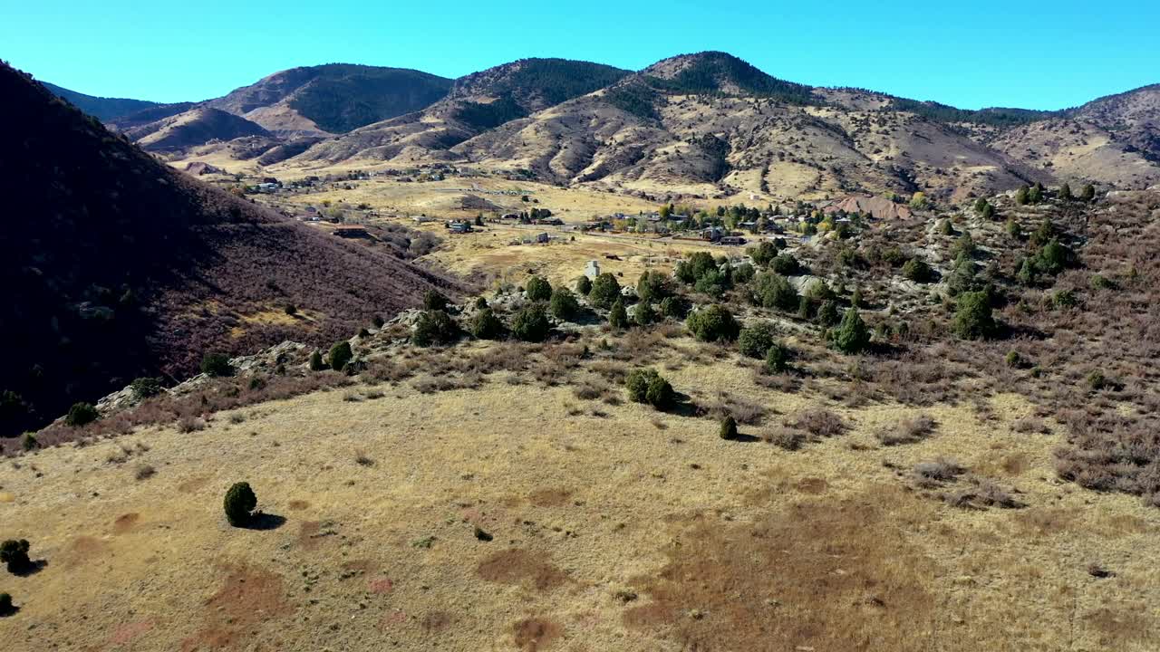 un vuelo panorámico de drones sobre un acantilado que captura la pequeña ciudad de morrison colorado