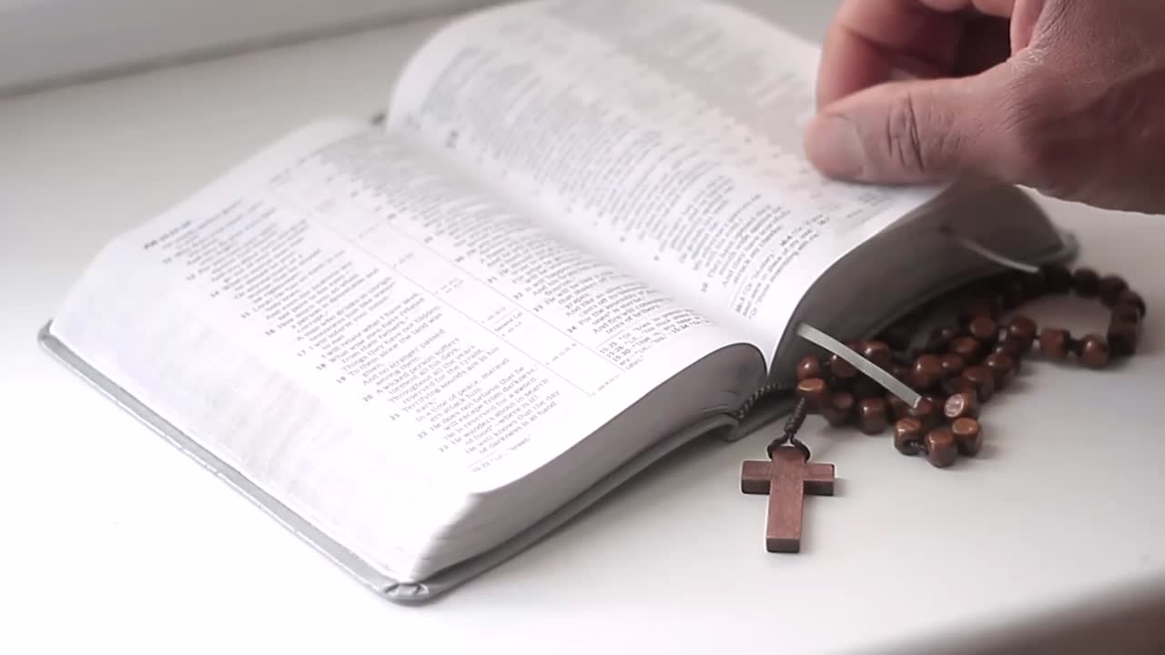 rezando a dios con las manos junto con la biblia y la cruz hombre negro rezando con fondo negro almacen de metraje de archivo