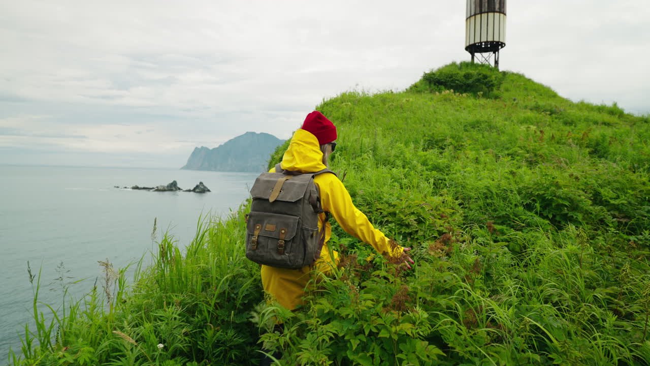 Woman Hiking on a Hilly Coastline with a View of the Ocean