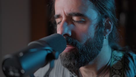 close up of a man singing into a microphone