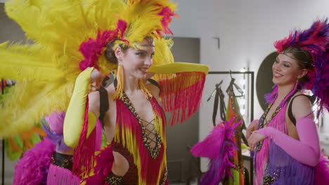 beautiful dancers with feather colorful gowns getting ready