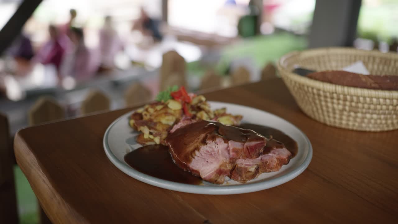 Toma en cámara lenta de un camarero sirviendo comida tradicional europea en un restaurante al aire libre