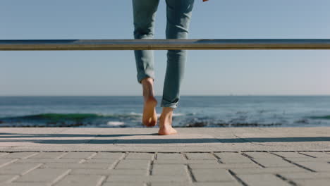 woman legs walking barefoot on seaside pier enjoying relaxing summer vacation watching beautiful ocean