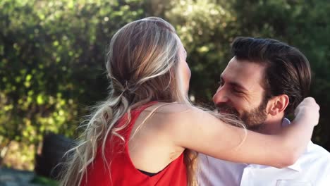 hombre sonriente ofreciendo anillo de compromiso mientras le propone a la mujer