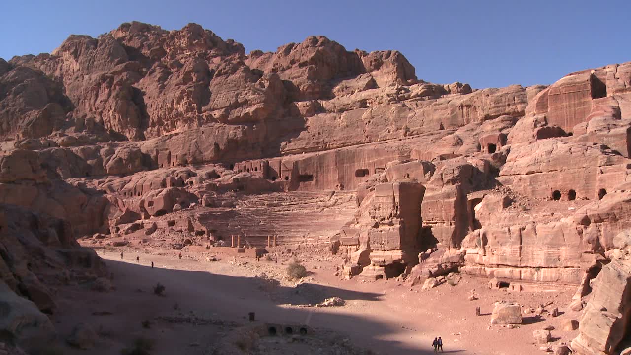 la gente monta burros cerca del antiguo anfiteatro en las antiguas ruinas nabateas de petra jordan 1
