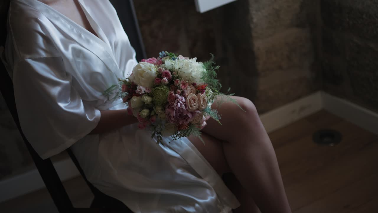 Elegant clutch of soft pink blooms amid flowing white fabrics in tranquil repose