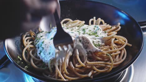 Mezclando-Pasta-De-Espagueti-En-Un-Plato-Con-Salsa-De-Yogur-Griego-Y-Perejil-Picado