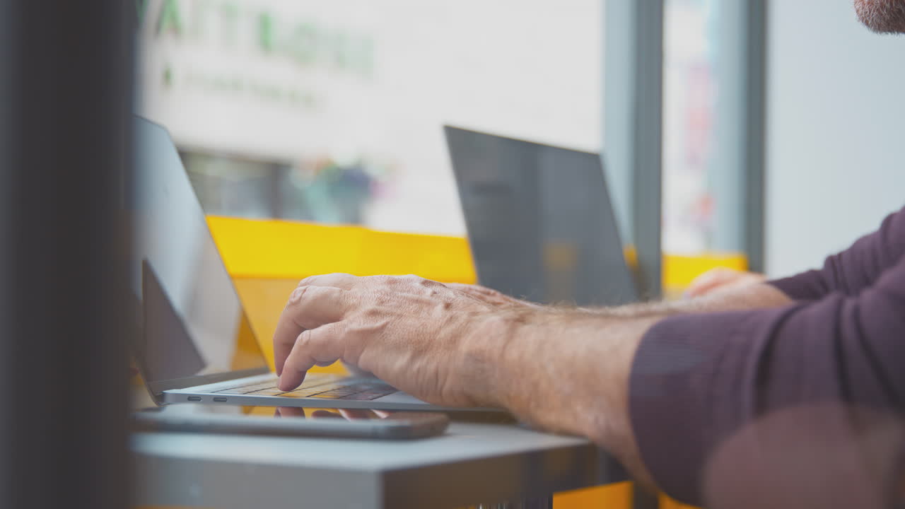 close up de los clientes en la ventana de la cafetería trabajando en portátiles