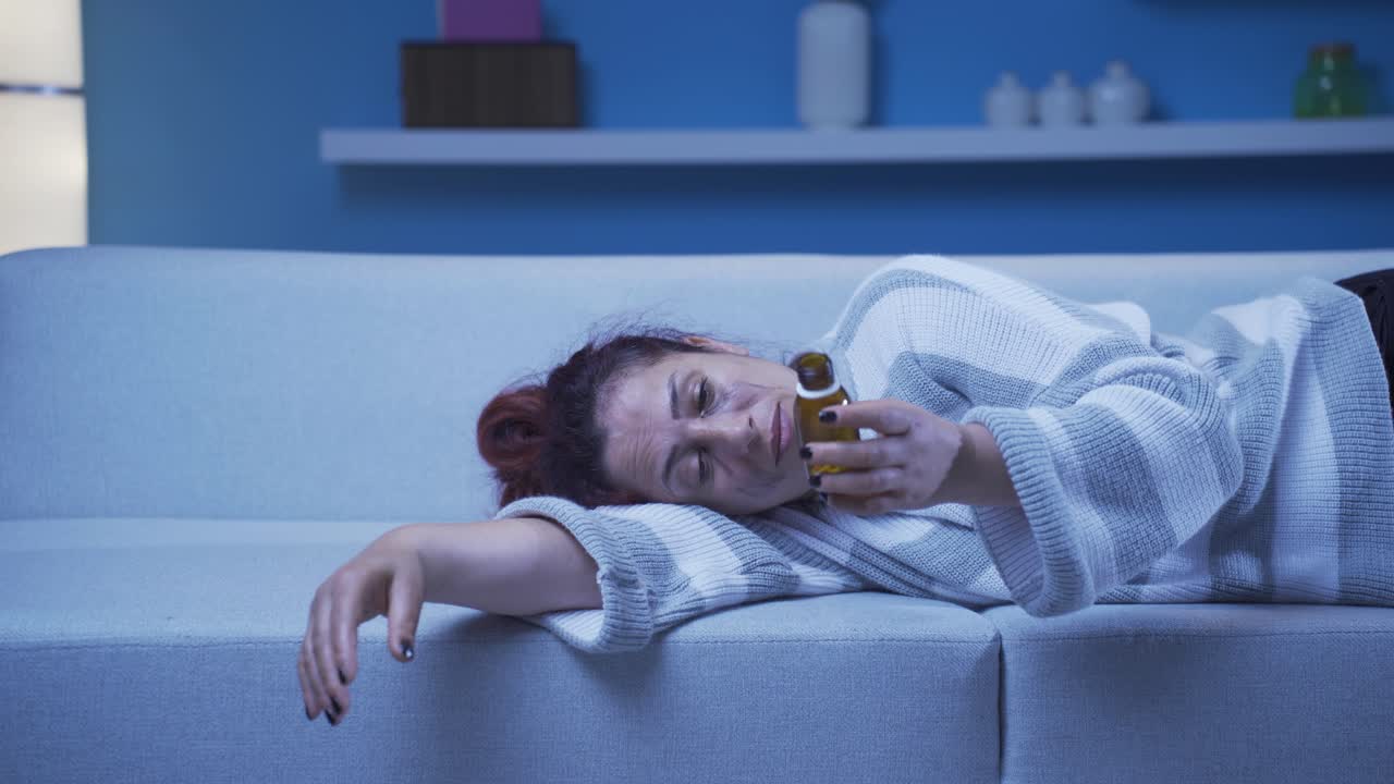 la mujer que mira las pastillas en su mano y va a suicidarse.