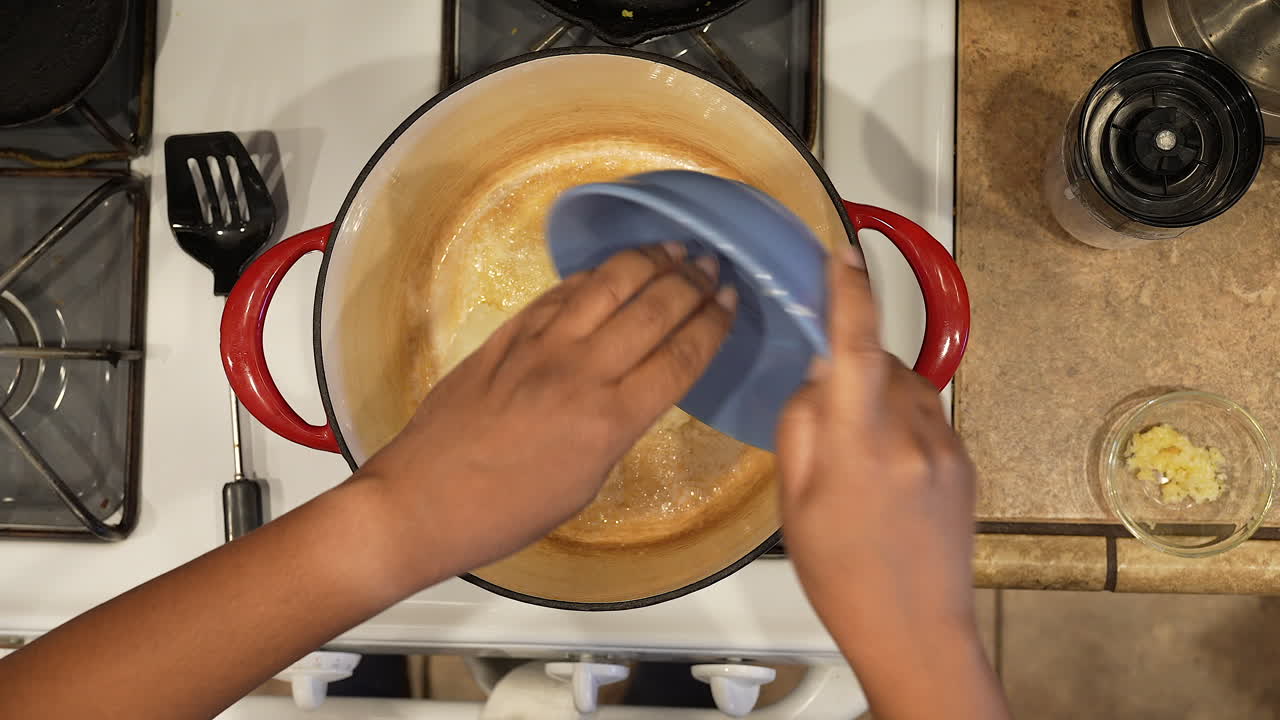 verter cebollas picadas en una olla caliente con mantequilla derretida para saltearlas en una receta casera: serie de arroz salvaje superior