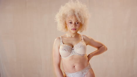retrato de estudio de una mujer albina natural y segura en ropa interior que promueve la positividad corporal