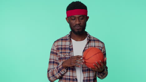 bearded happy african american young man basketball sport fan holding ball looking at camera