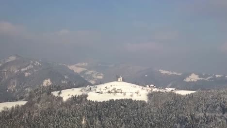 The-picturesque-church-of-Sveti-Tomaz-on-the-top-of-the-hill-in-central-Slovenia-during-winter