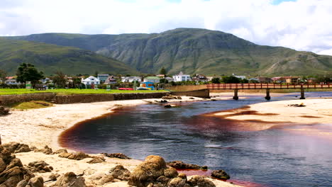 Malerisches-Küstengebiet-Von-Kleinmond-Mit-Lagunenwasser,-Das-Unter-Der-Berühmten-Fußgängerbrücke-Fließt