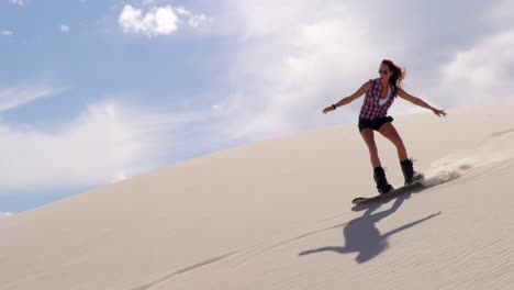 Woman-sand-boarding-on-the-slope-in-desert-4k