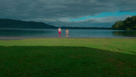 couple swimming in lake rotoma, rotorua, new zealand