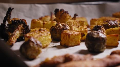 a close up shot panning across a baking tray filled with chicken strips and vegetables roasting in a hot kitchen oven, a healthy balanced meal currently being cooked to perfection